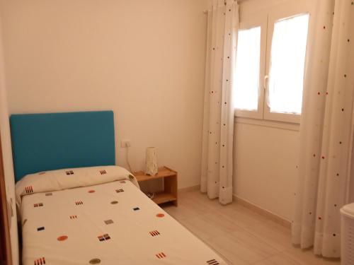 プエルティト・デ・グイマルにあるSea Wiews Ana3のベッドルーム1室(青いヘッドボード付きのベッド1台、窓付)