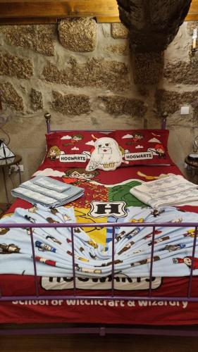 a bed with a blanket on top of it at Casa da Relva Experiência Temática Inspirada em Harry Potter in Lamego