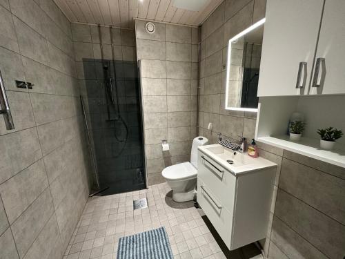 een badkamer met een douche, een toilet en een wastafel bij Oceanic & trendy two bedroom apartment with FREE parking in Helsinki