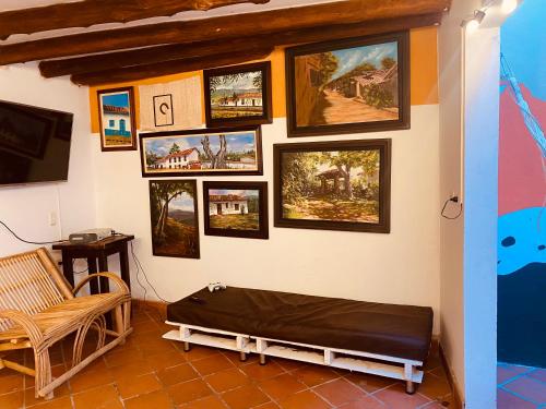 Cette chambre comprend un lit et des photos sur le mur. dans l'établissement Hostal Casa Ceiba, à Barichara