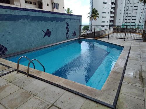 a swimming pool with blue water in front of a building at BOA VIAGEM FLATS APTO 201 in Recife
