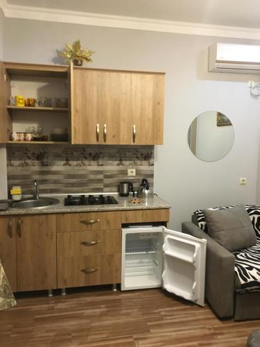 a kitchen with wooden cabinets and a sink and a couch at hotel twins G&G in K'obulet'i