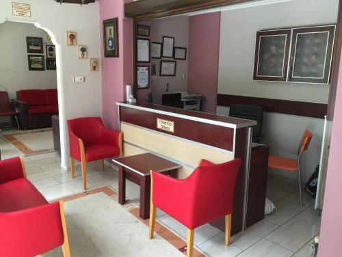 チャナッカレにあるÇanakkale Kampüs Pansiyonの赤い椅子とテーブルが備わる待合室