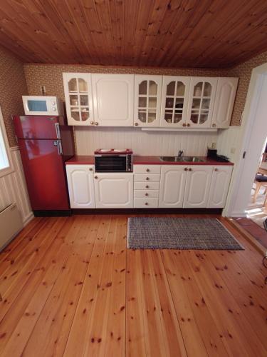 cocina con armarios blancos y nevera roja en Villa Naffen1 en Malmö
