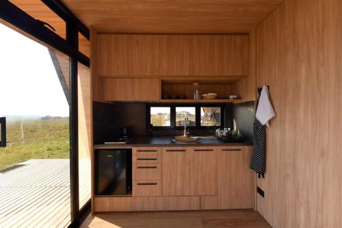a kitchen in a tiny house with a deck at Valle Fiori in Balsa Nova
