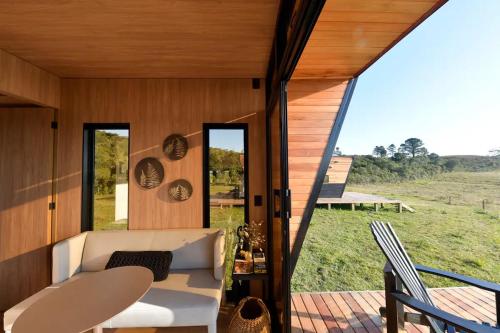 a living room with a white couch and a large window at Valle Fiori in Balsa Nova