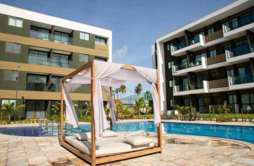 a gazebo by a swimming pool next to a building at Mana Beach Experience in Ipojuca