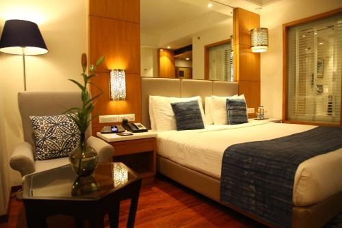 Habitación de hotel con cama y silla en The Place Gurugram, a member of Radisson Individuals, en Gurgaon