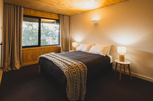 um quarto com uma cama, uma janela e uma mesa em Kunama Townhouses em Jindabyne