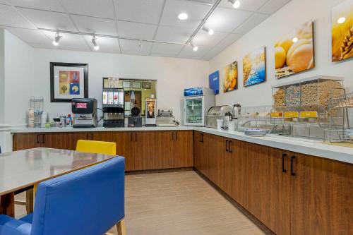 a fast food restaurant with a table and blue chairs at Comfort Suites Houston NW - Vintage Park in Houston