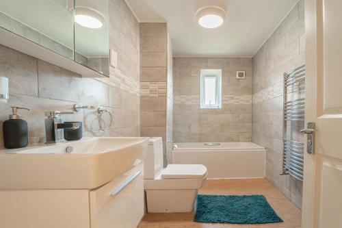 a white bathroom with a sink and a toilet at Luxury Riverview 2Bed Apt- 5 mins from Excel London, Canary wharf, 02 Arena - Free Parking - PlayStation 4 Provided in London