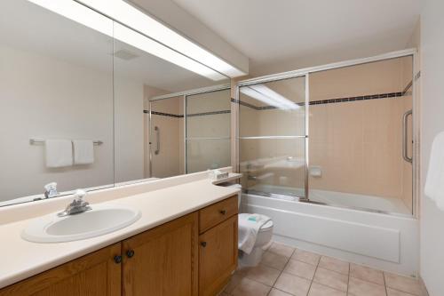 a bathroom with a sink and a shower and a toilet at The Woodrun Lodge by Whiski Jack in Whistler