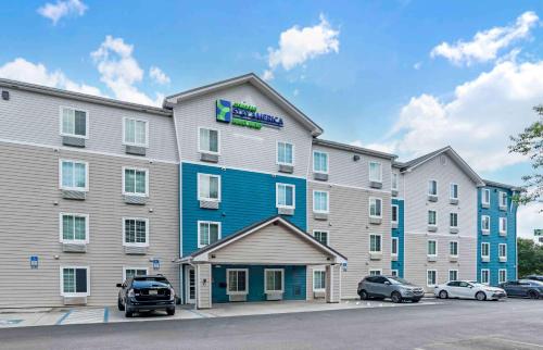 a large apartment building with cars parked in a parking lot at Extended Stay America Select Suites - Pensacola - Northwest in Pensacola