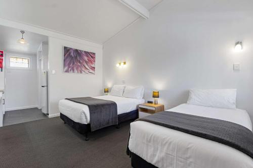 a hotel room with two beds and a bathroom at Econo Lodge East Adelaide in Adelaide