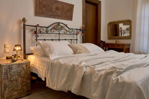a bedroom with a large bed with white sheets at Thalassoxyla Portaria in Portariá