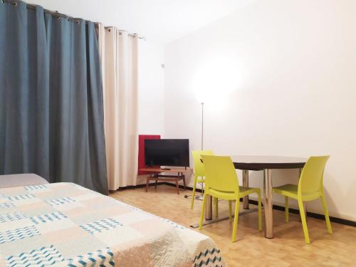 Una habitación con una mesa y sillas y un televisor. en Trento Degasperi 16, en Trento