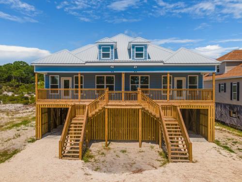 une maison avec une grande terrasse sur la plage dans l'établissement Southern Dunes West - 332 Audubon Pl Unit A home, à Dauphin Island