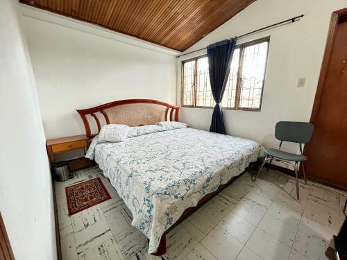 1 dormitorio con 1 cama y 1 silla en CASA FAMILIAR CENTRICA, en Duitama