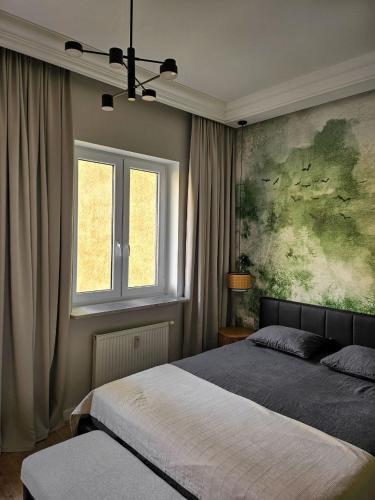 a bedroom with two beds and a painting on the wall at MIRA Apartment in My Center in Szczecin