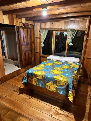 a bedroom with a bed in a wooden room at La Casa de Cecilia Mindo in Mindo