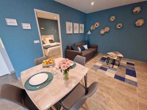 un salon avec une table, des chaises et un canapé dans l'établissement Au Douni - Jacuzzi, jardin, parking couvert et bureau équipé, à Aubais