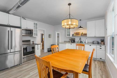a kitchen with a wooden table and a kitchen with white cabinets at The Nighthawk Eyrie in Stanwood