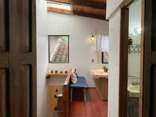 a bathroom with a bench and a sink and a mirror at Casa PiYo in San Cristóbal de Las Casas