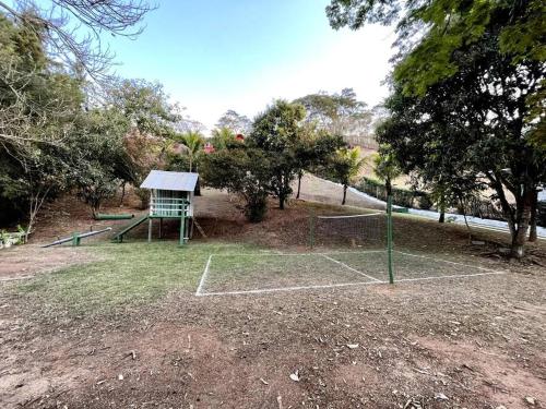 a tennis court with a net in a park at Casa em Secretário (@chacaradosolsecretario) in Petrópolis