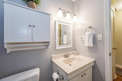a white bathroom with a sink and a mirror at Kelly's Comfortable Quinton Home in Quinton