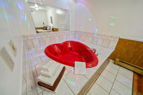 a large red bath tub in a bathroom at Kingsway Inn in Caro