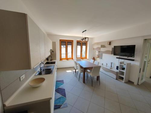 uma cozinha e sala de estar com uma mesa e uma sala de jantar em Appartamento Peç em Sùtrio
