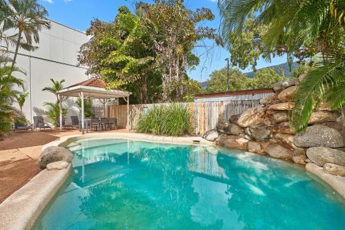 ein Swimmingpool in einem Hof mit einer Felswand in der Unterkunft Coral Horizons Ocean View Apartments in Palm Cove