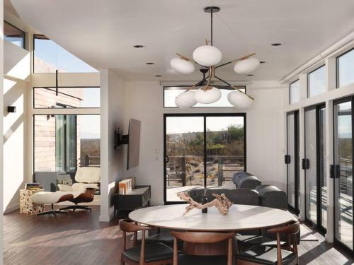 uma sala de estar com uma mesa e um sofá em Panoramic Heaven - Luxury Designer Property w Spa em Joshua Tree