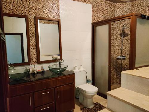 La salle de bains est pourvue de toilettes, d'un lavabo et de miroirs. dans l'établissement Duplex Elias, à Marrakech