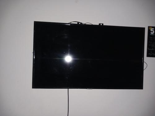 TV de pantalla plana en una pared blanca en Casa camacho, en Villavicencio