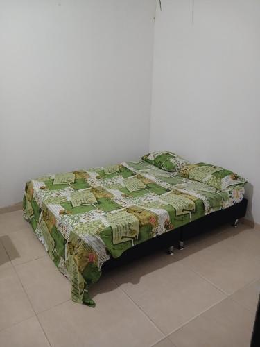 Bett mit einer Decke auf dem Zimmer in der Unterkunft Casa camacho in Villavicencio