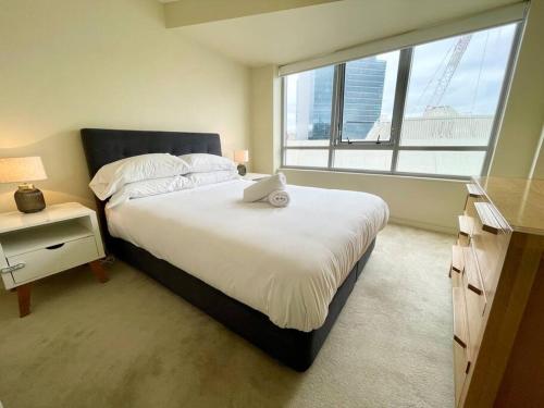 una camera con un grande letto e una grande finestra di North Sydney 2 Bedroom - Pool Parking Gym Spa Sleeps 6 a Sydney