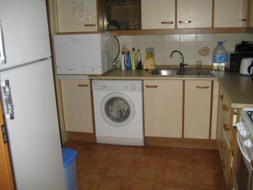 a kitchen with a washing machine and a sink at AMPOLLA in L'Ampolla