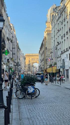 una calle de la ciudad con bicicletas estacionadas en una calle adoquinada en LovelyParis——Studio au coeur de Paris 2 en París