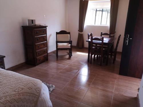 1 dormitorio con mesa y sillas y comedor en Villa Dante, en Firavitoba