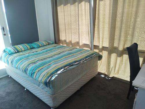 a bed in a room with a window with curtains at Comfy bed quiet neighbourhood in Grovedale