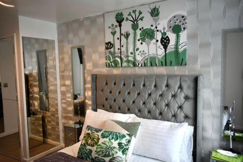 een slaapkamer met een bed met een metalen hoofdeinde bij Tottenham Hotspurs Stays at the Gascoigne Suite in Londen