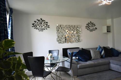 a living room with a couch and a glass table at Tottenham Hotspurs Stays at the Gascoigne Suite in London