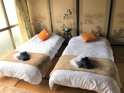two beds sitting next to each other in a room at Astuto Riders House in Annaka