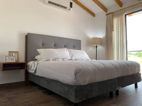 1 dormitorio con 1 cama grande y ventana grande en Casa More con alberca, jacuzzi, climatizada, en Tequesquitengo