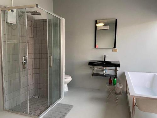 a bathroom with a glass shower and a sink at Alley51 Hotel in Suratthani