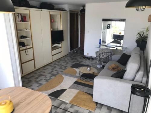 een woonkamer met een bank en een tafel bij Agde : appartement vue sur le port in Cap d'Agde