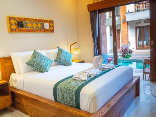 a bedroom with a bed and a pool at Arumasta Ubud in Ubud