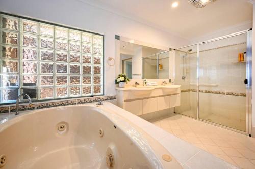 Un baño grande con bañera y ducha. en Sunshine Coast Dream Getaway, en Pelican Waters