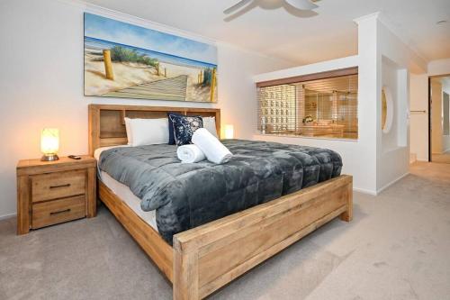 Un dormitorio con una cama grande y un cuadro en la pared. en Sunshine Coast Dream Getaway, en Pelican Waters